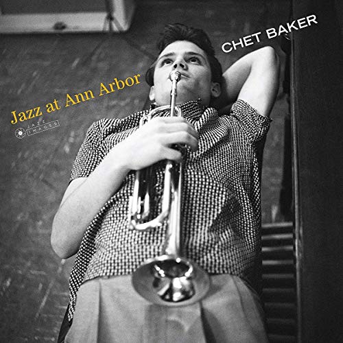 Black and white photo of Chet Baker holding a trumpet, reclining on a chair.