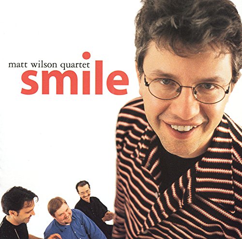 "Album cover with a smiling man and three others in the background."