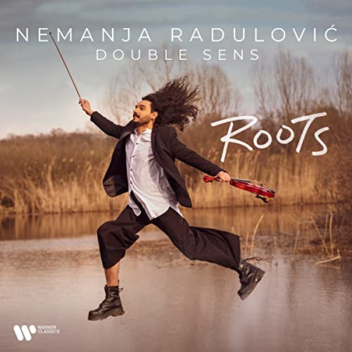 Violinist Nemanja Radulović mid-leap with violin and bow, outdoor setting.