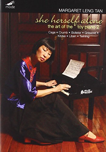 Margaret Leng Tan seated at a piano, sheet music in hand.