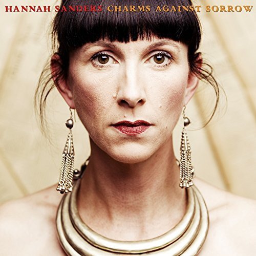 Album cover featuring a woman with dark hair, bangs, and ornate jewelry against a beige background.