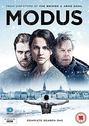 "Modus DVD cover featuring three people and a man in snowy water, cityscape below."