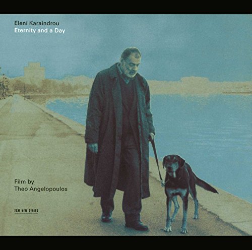 "CD cover featuring a man walking a dog along a waterfront path."