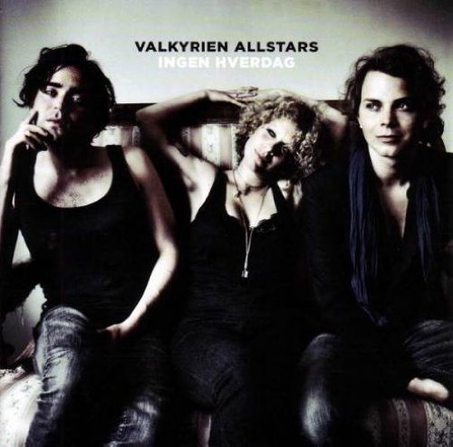 "Album cover with three women sitting on a couch, wearing dark clothing."