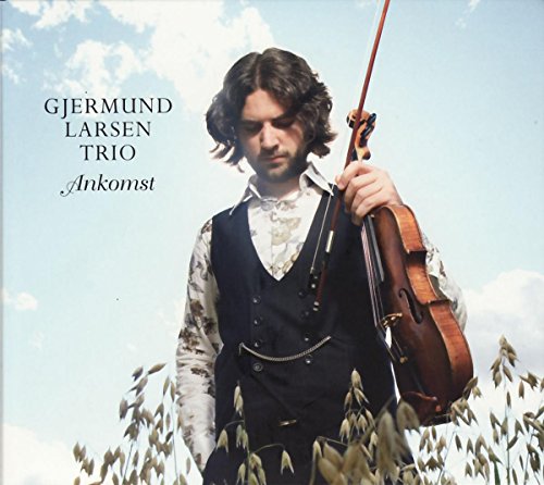 Man with violin in a field under a blue sky.