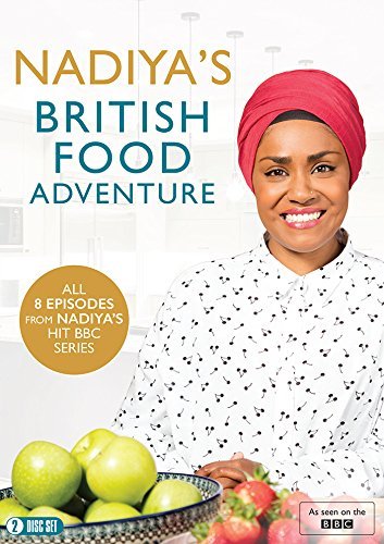 Nadiya Hussain wearing a pink headscarf behind a bowl of green apples and strawberries.