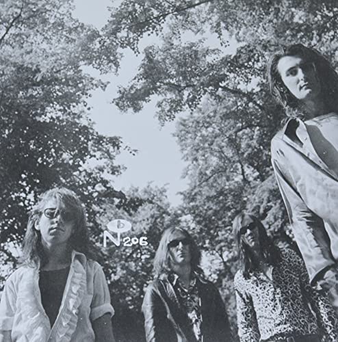 Black and white photo of four people with long hair outdoors.