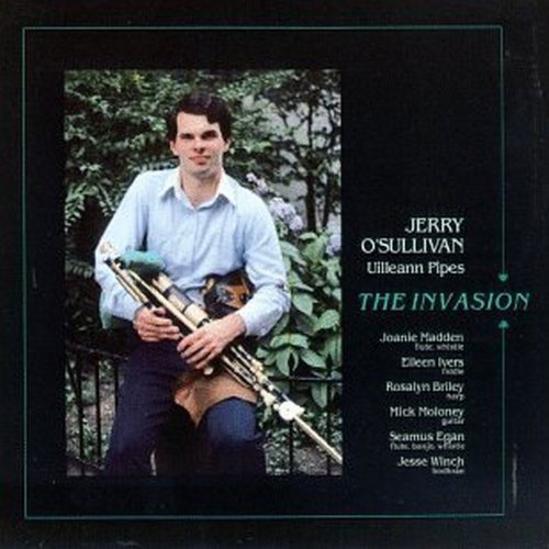 "Album cover with man holding pipes, surrounded by greenery, on a black background."
