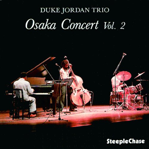 Jazz trio performing on stage with piano, cello, and drums under red lighting.