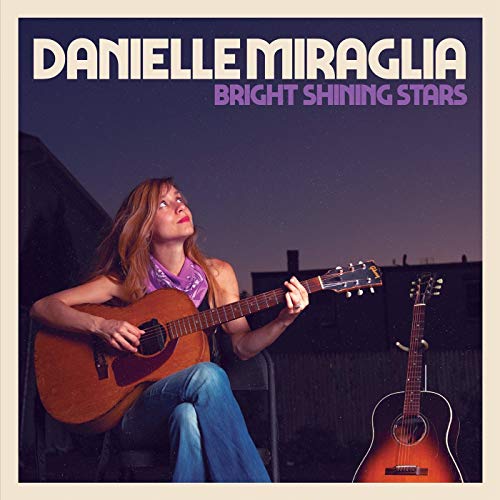 "Album cover featuring a woman playing guitar, with another guitar beside her."