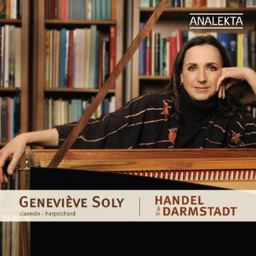 A woman rests her hand on a harpsichord in front of a bookshelf.