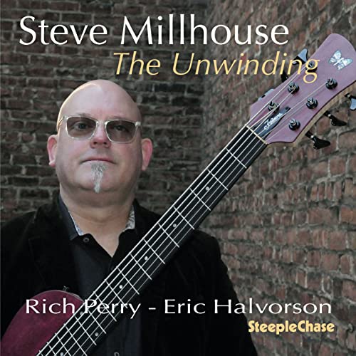 AlbumBCH CD cover of Steve Millhouse holding a bass guitar against brick wall.