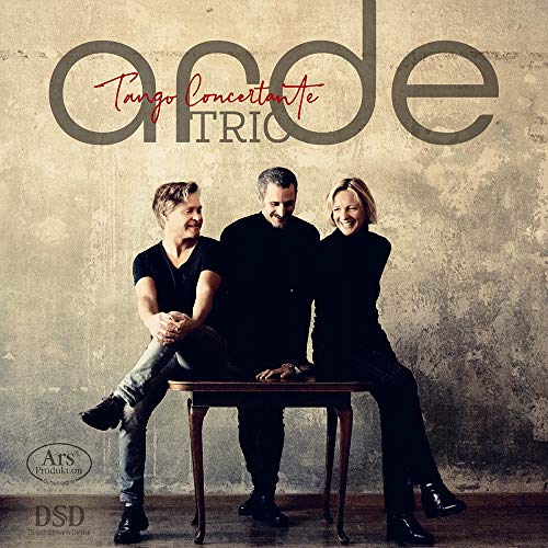"CD cover featuring three musicians sitting on a table against a textured wall."