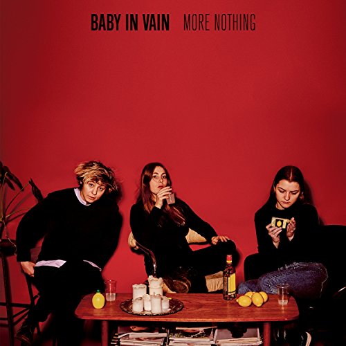 Red album cover featuring three people seated around a table.