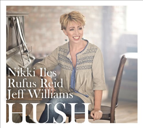 "Album cover featuring a smiling woman sitting on a chair beside a piano."