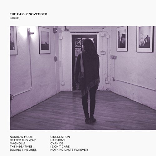 Album cover with a person in a dimly lit hallway with framed photos on the walls.