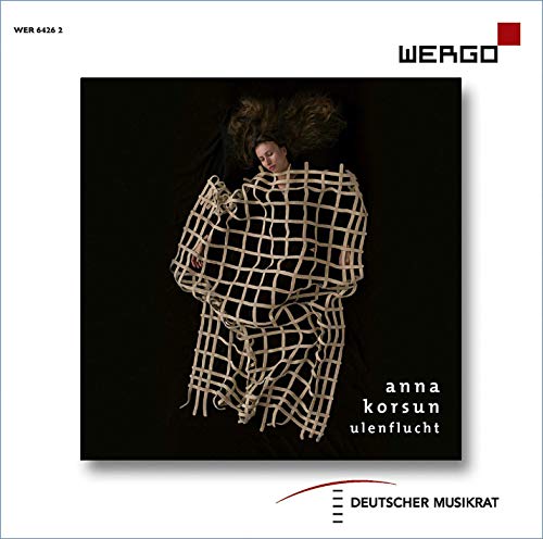 A CD cover featuring a person wrapped in a grid-like structure against a black background.