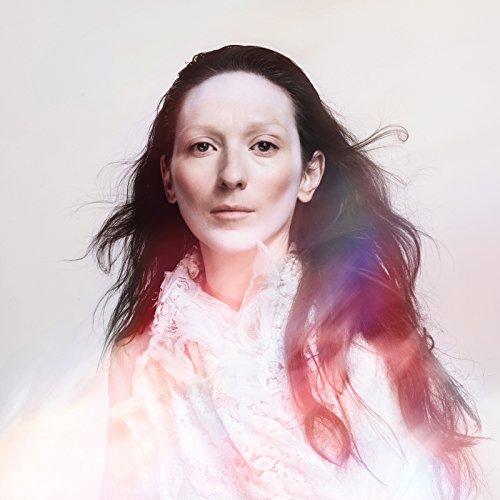 Portrait of Tilda Swinton with long dark hair and pale skin.