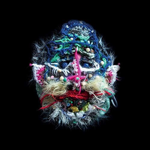 A colorful, abstract, yarn-like sculpture of a face on a black background.