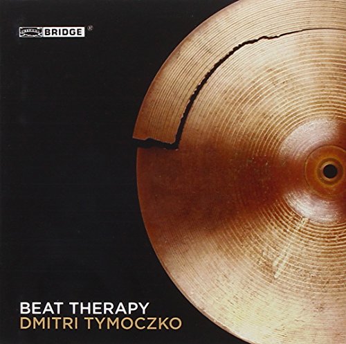"Album cover featuring a cracked cymbal against a black background with text."