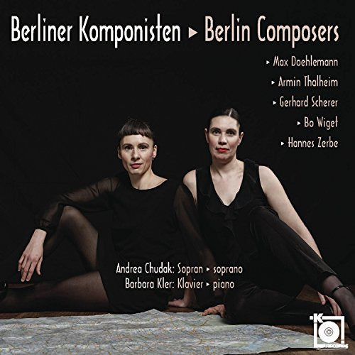 CD cover with two women in black sitting on a patterned rug against a dark background.