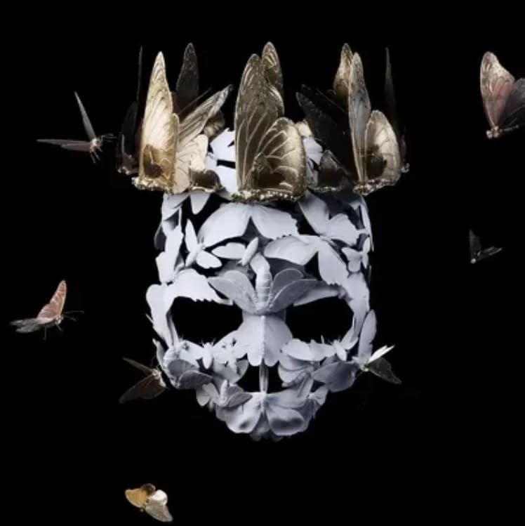 Skull and crown formed from butterflies against a black background.