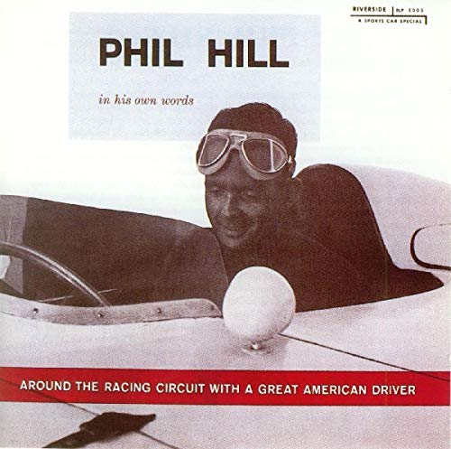 Phil Hill in racing gear, seated in a white sports car.