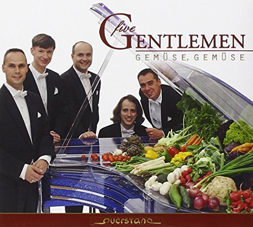 "Five men in tuxedos stand behind a car trunk filled with vegetables."