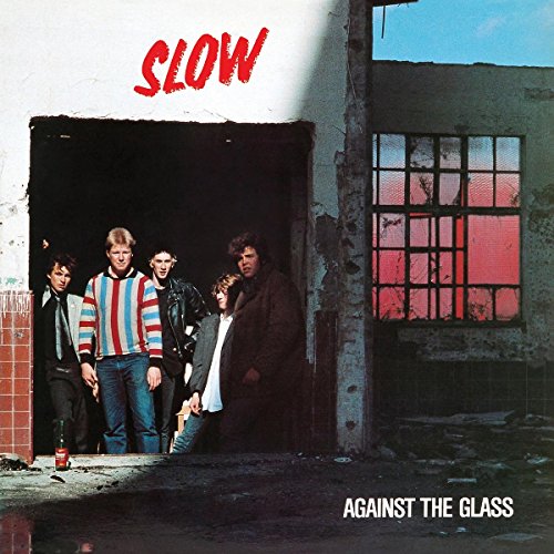 Five men stand in a doorway of a dilapidated building with red-tinted windows.