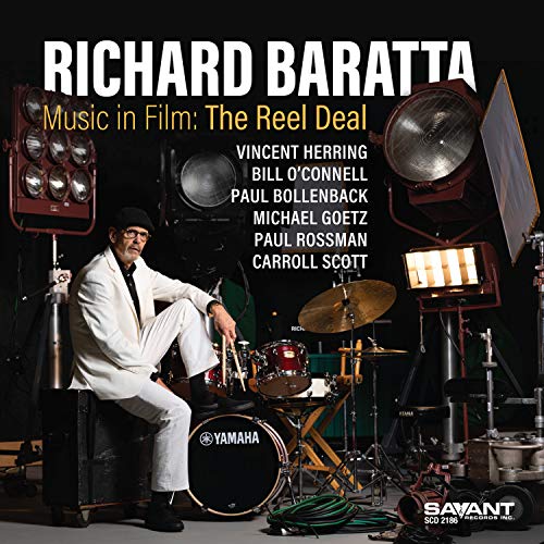 Album cover featuring a man in white sitting on a speaker beside a drum kit.