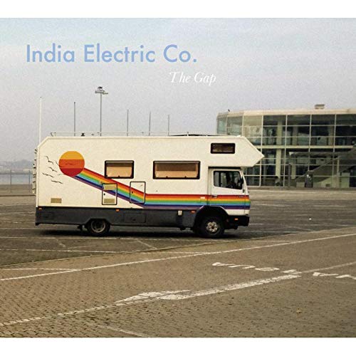 "Album cover featuring a white camper van with rainbow stripe in an empty lot."