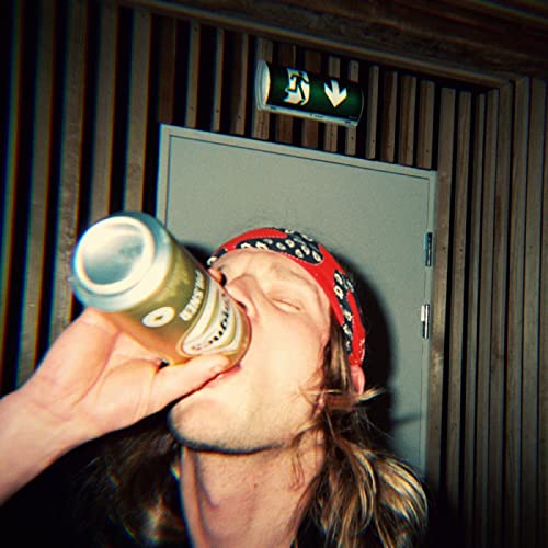 Person drinking from a can with a red bandana, indoors.