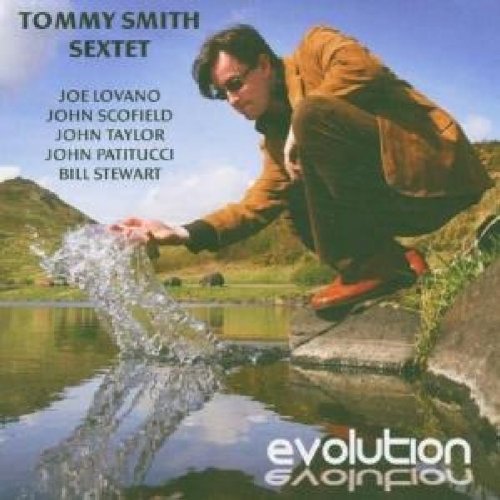 Man crouching by a pond, splashing water with his hand, on a music album cover.