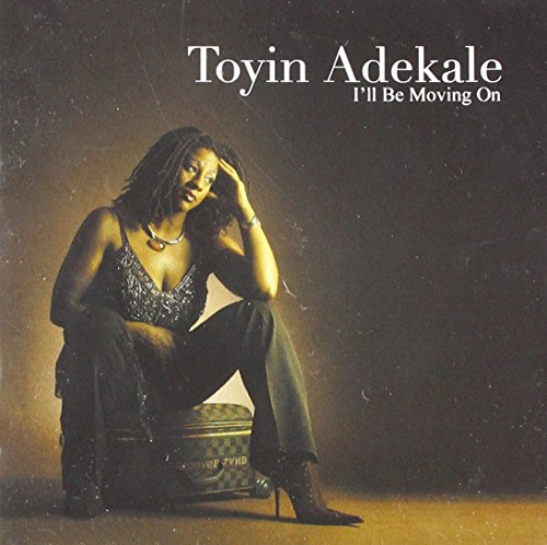 "Album cover featuring a woman sitting on a suitcase, dressed in sparkly attire."