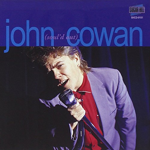 "CD cover featuring a man singing into a microphone, wearing a red shirt and grey jacket."