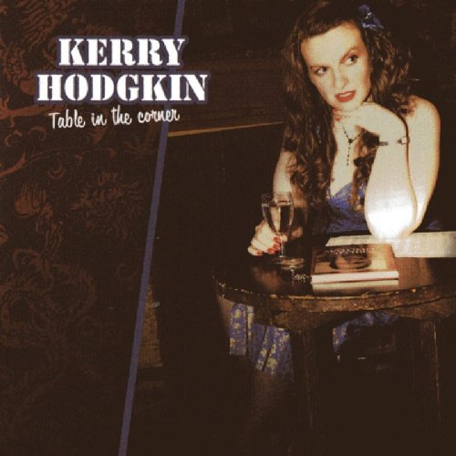 "Album cover featuring a woman sitting at a table with a wine glass."