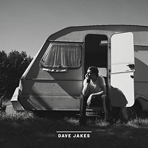 Black and white vinyl album cover with man sitting outside a camper van.