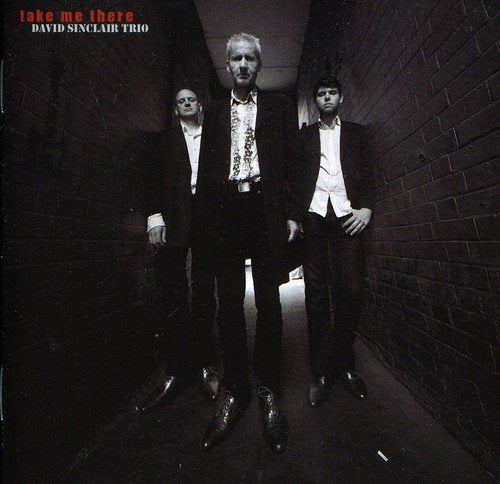 "Album cover featuring three men in suits standing in a dark alleyway."
