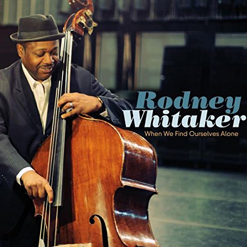 Man in suit and hat plays double bass on album cover with artist's name.