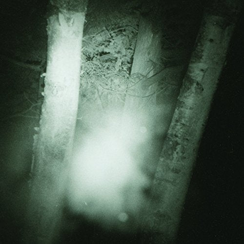 A blurry, dark image with three vertical poles and a central white glow.