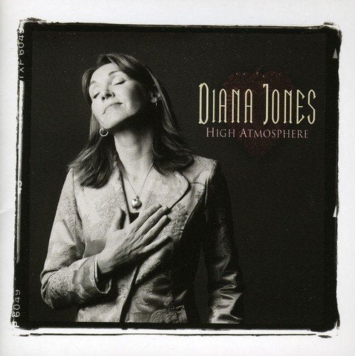 "Diana Jones' album cover, black and white photo of a woman, dark background."