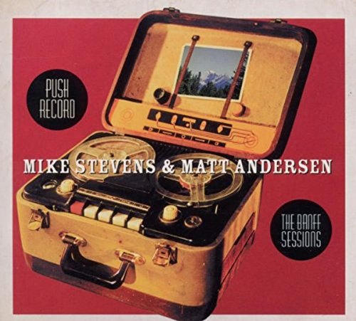 Album cover featuring a vintage suitcase with a reel-to-reel tape recorder inside, on red background.