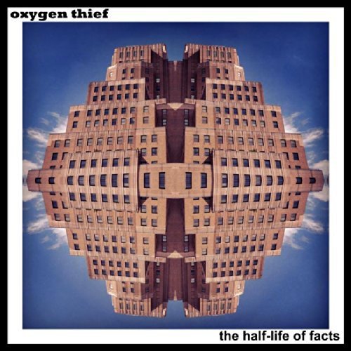 Album cover featuring a mirrored, symmetrical building against a blue sky.