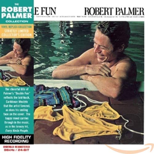 Robert Palmer smiling in a swimming pool with yellow swimwear on the pool deck.