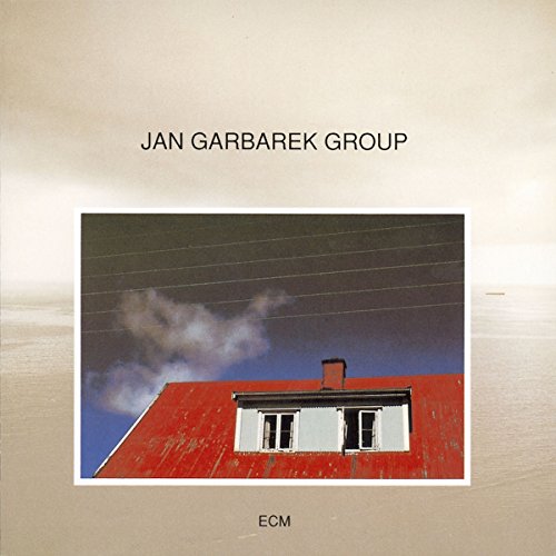 Album cover featuring a red-roofed house with a blue sky and white clouds.