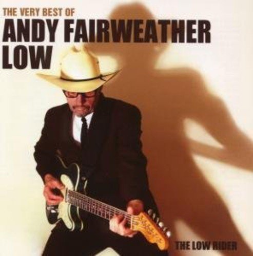 Man in a white cowboy hat and black suit plays a guitar.