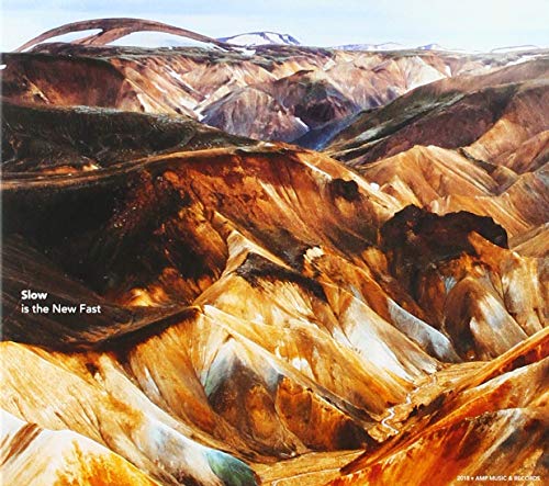 "Album cover featuring a landscape of brown, rocky hills with the text 'Slow is the New Fast'."