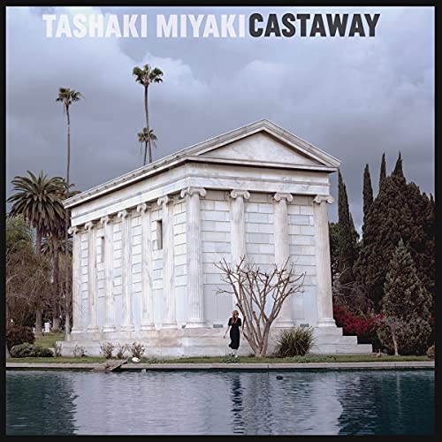 Vinyl album cover: classical building with palm trees and a figure.