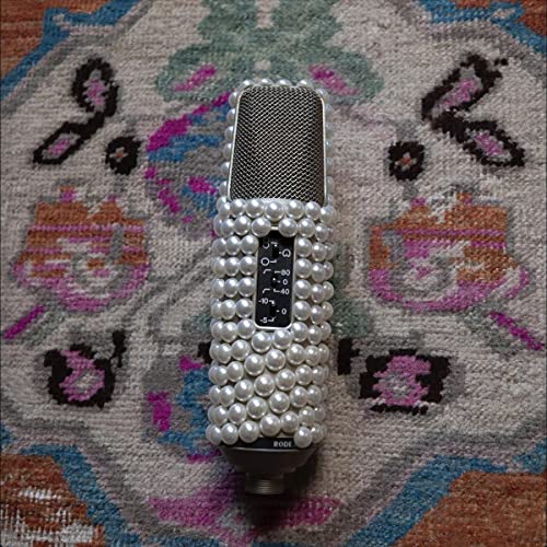 Microphone decorated with pearls rests on a patterned rug.