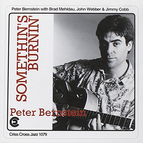 "Album cover with a black-and-white photo of a man holding a guitar."